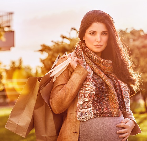 Portrait of beautiful pregnant woman with shopping bag outdoors